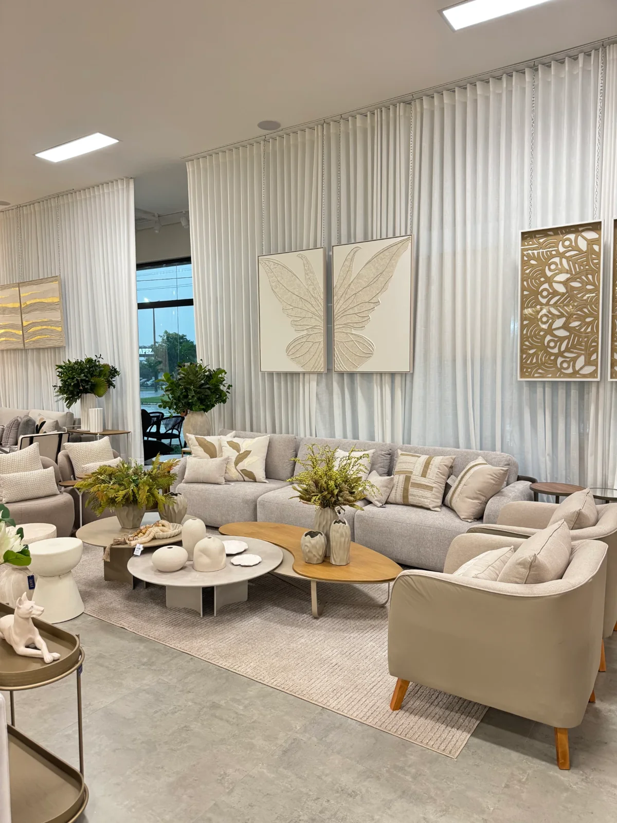 Sala decorada com sofá, poltronas e objetos da Quintal Home Decor